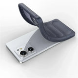 A flexible dark gray phone case being removed from or placed onto a white smartphone with two prominent cameras.