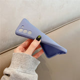 Flexible lavender phone case with dark green manicured fingernail holding it.