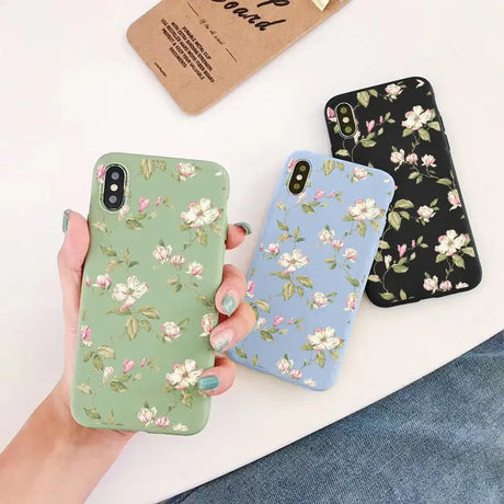 a woman holding a phone case with flowers on it