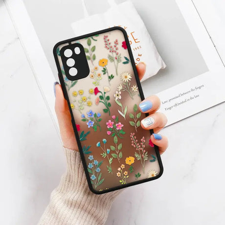 a woman holding a phone case with flowers on it