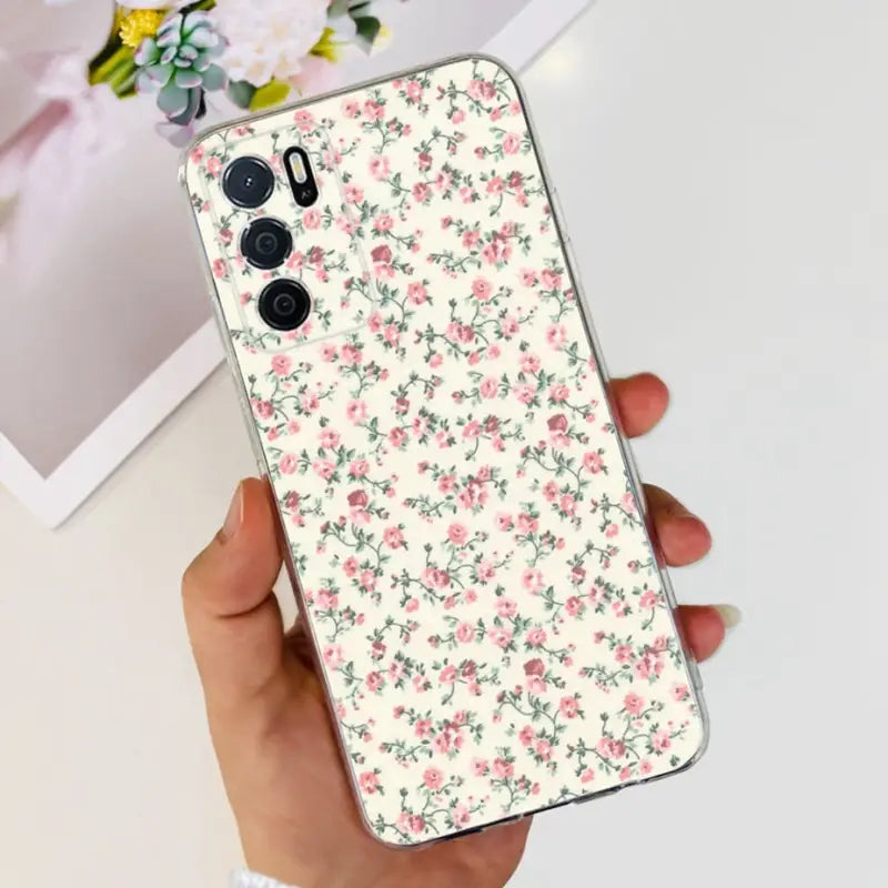 a woman holding a phone case with a floral pattern