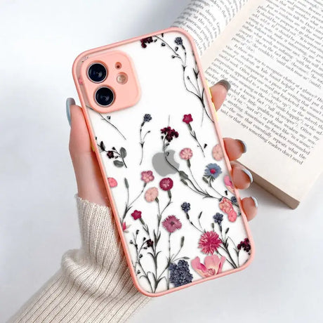 a woman holding a phone case with flowers on it