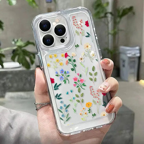 a woman holding a phone case with flowers on it