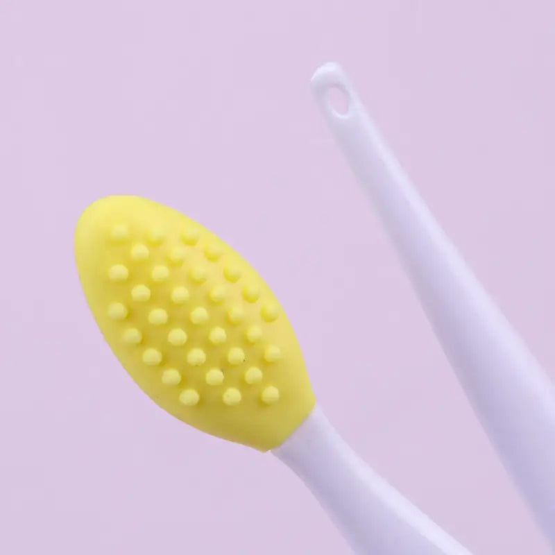 a yellow toothbrush on a pink background