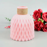 a pink vase with a rope wrapped around it