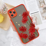 a woman holding a phone case with red flowers on it