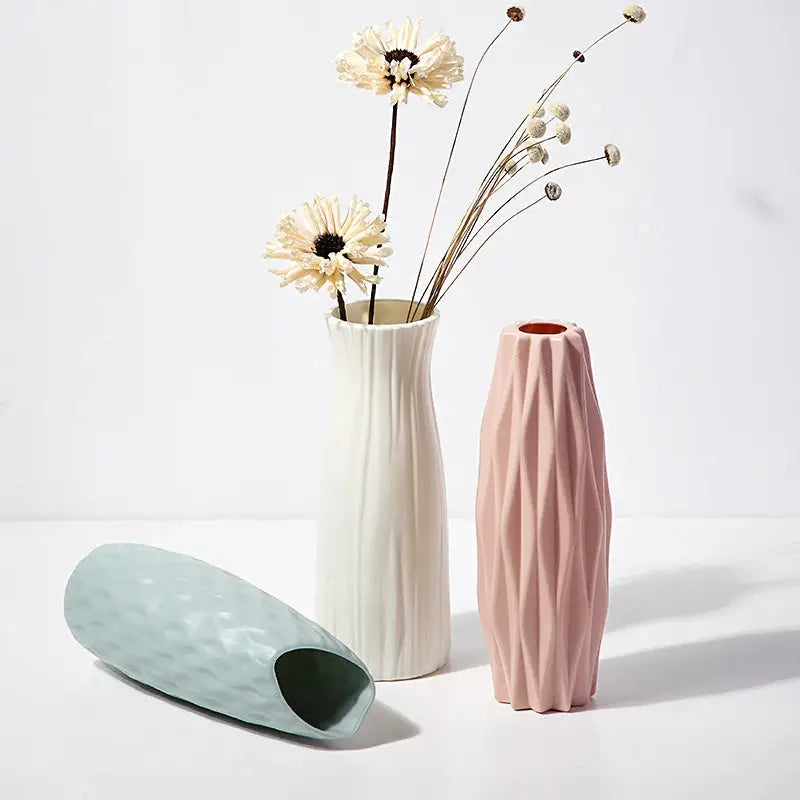 there are two vases with flowers in them on a white surface