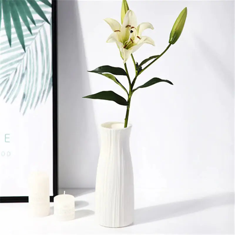 a white vase with a flower in it