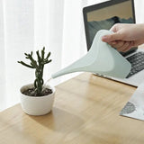 a person using a watering watering device on a desk