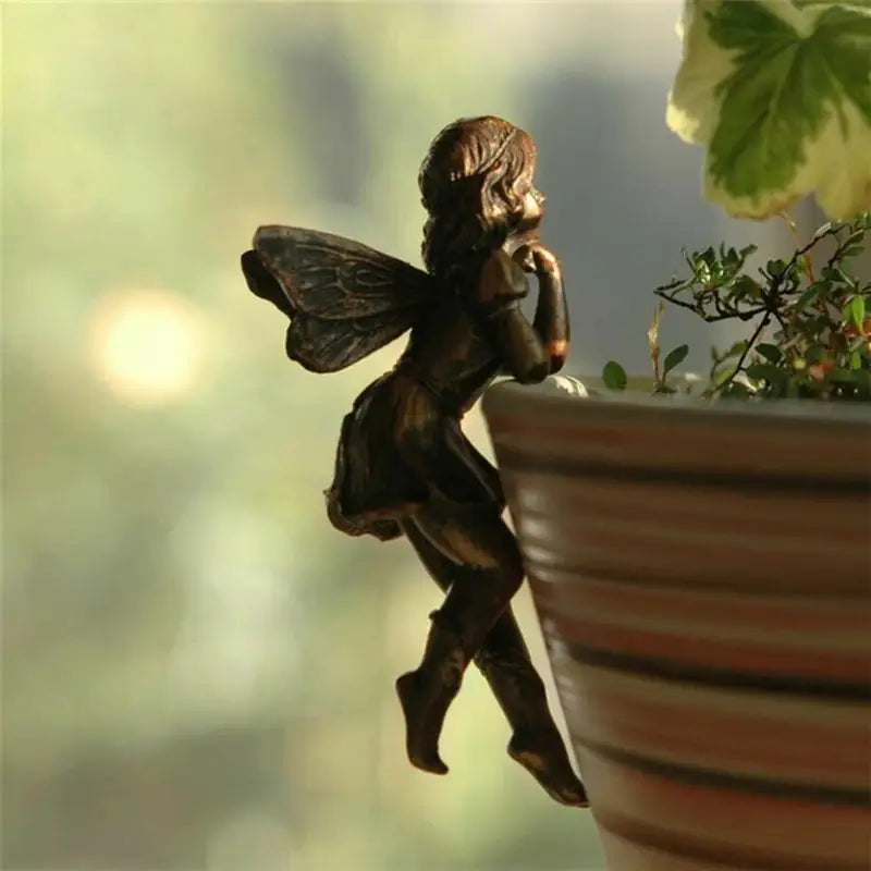 a small fairy sitting on top of a pot