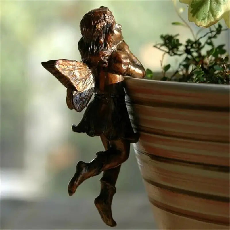 a statue of a fairy sitting on a pot