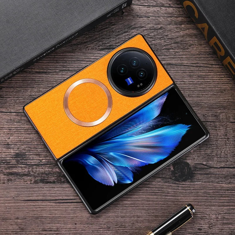 Foldable smartphone with a bright orange exterior and circular camera module, displaying a blue feather image on its screen.