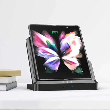 Foldable smartphone or tablet displaying a colorful butterfly image on its screen, docked in a charging stand.