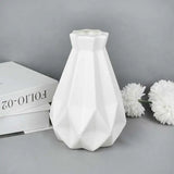 a white vase with a flower on top