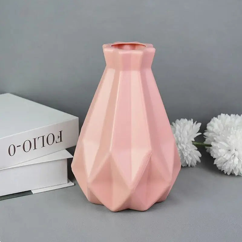 a pink vase sitting on top of a white box