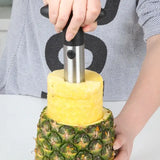 someone is cutting a pineapple with a knife on a table