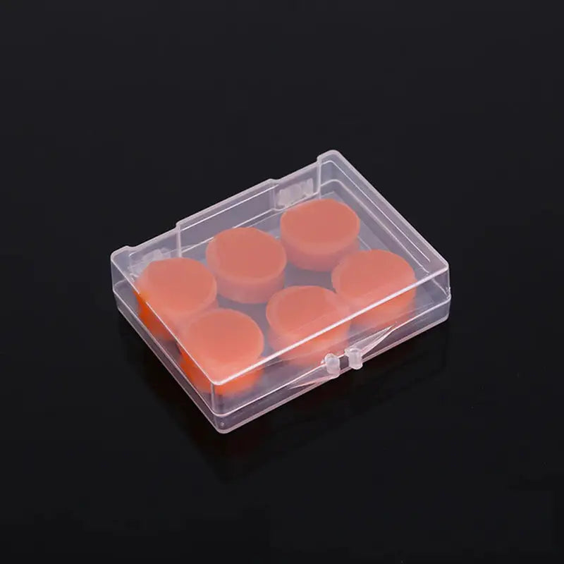 a small plastic box with six orange candles inside