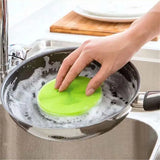 a person using a green brush to clean a sink