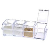 a clear plastic box with three compartments and a small piece of sand inside