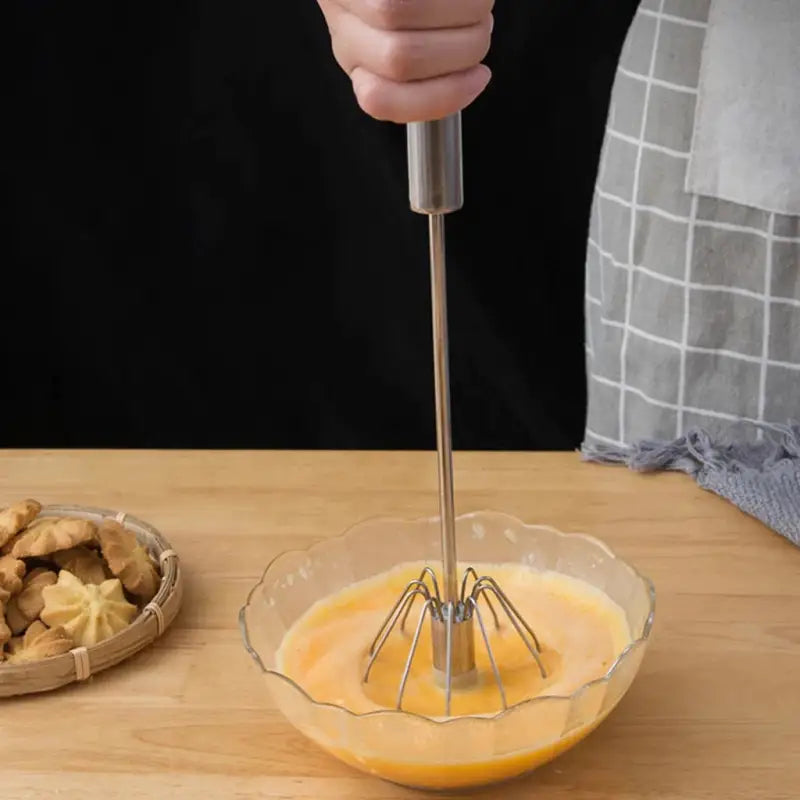 a person is mixing a bowl with a whised whised egg