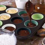 a person pouring chocolate into a muffins