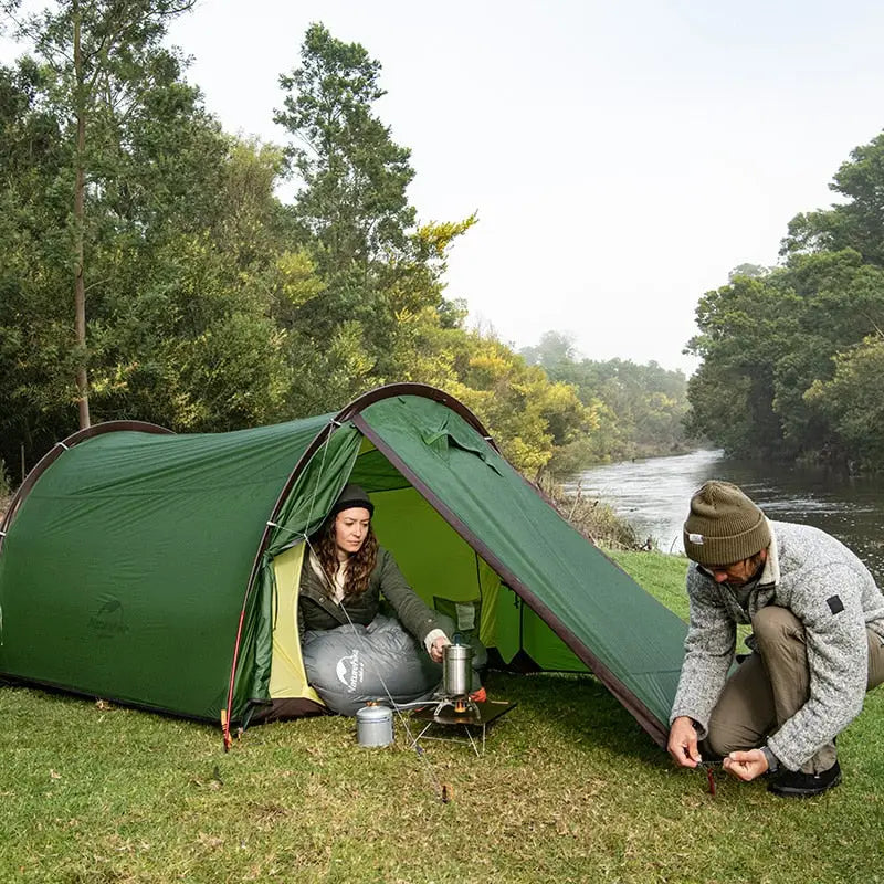 a man and woman setting up a tent