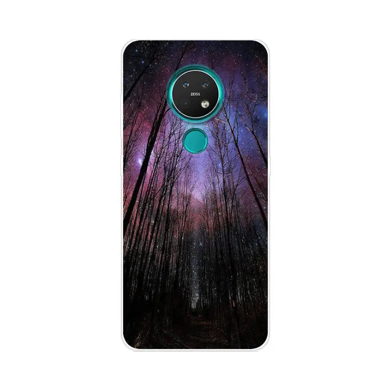 a close up of a phone with a forest and a purple sky