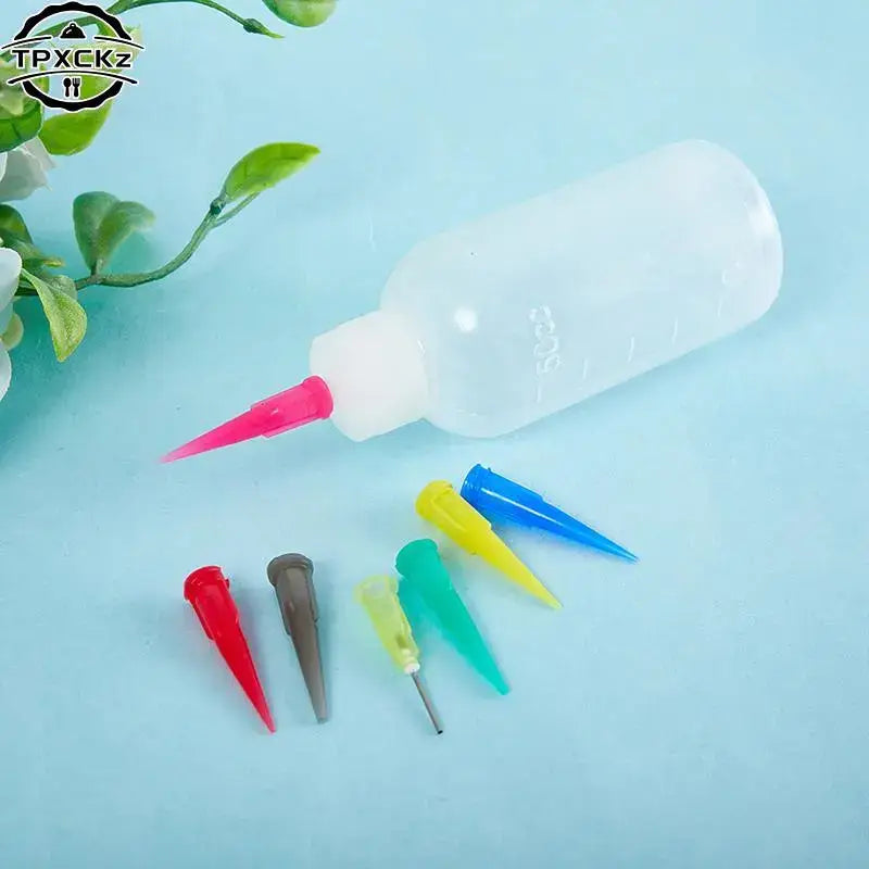 there are four different colored plastic needles and a bottle of glue