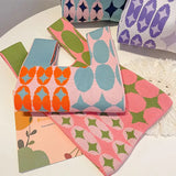 four colorful floral print pillows on a white table