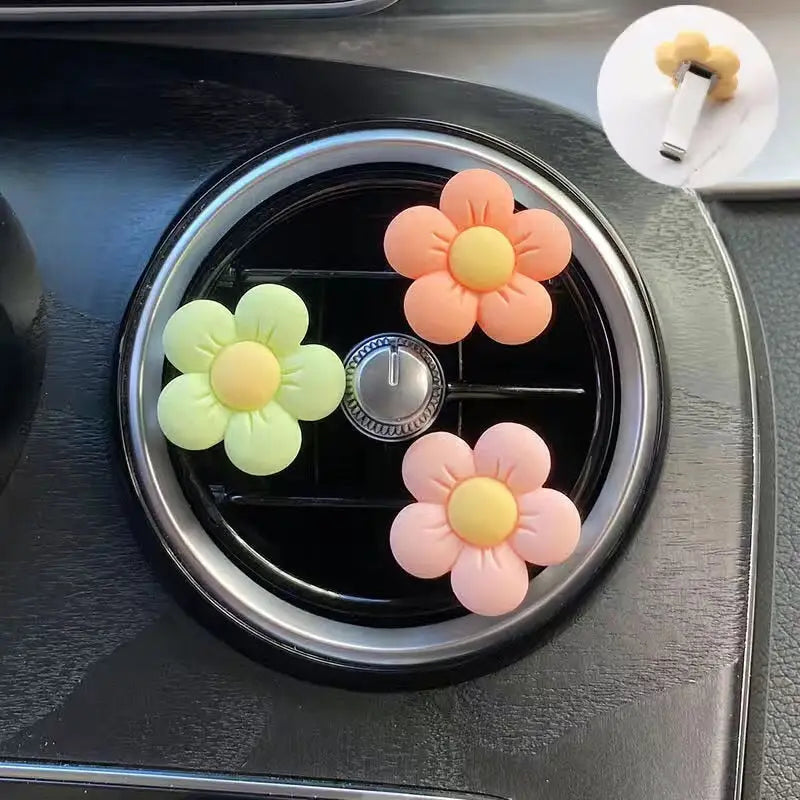 there are four flowers on the center of a car air vent