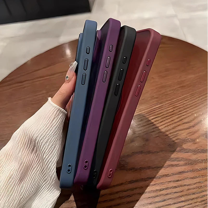 Four smartphones in different colors (blue, purple, black, and burgundy) held in a person’s hand.