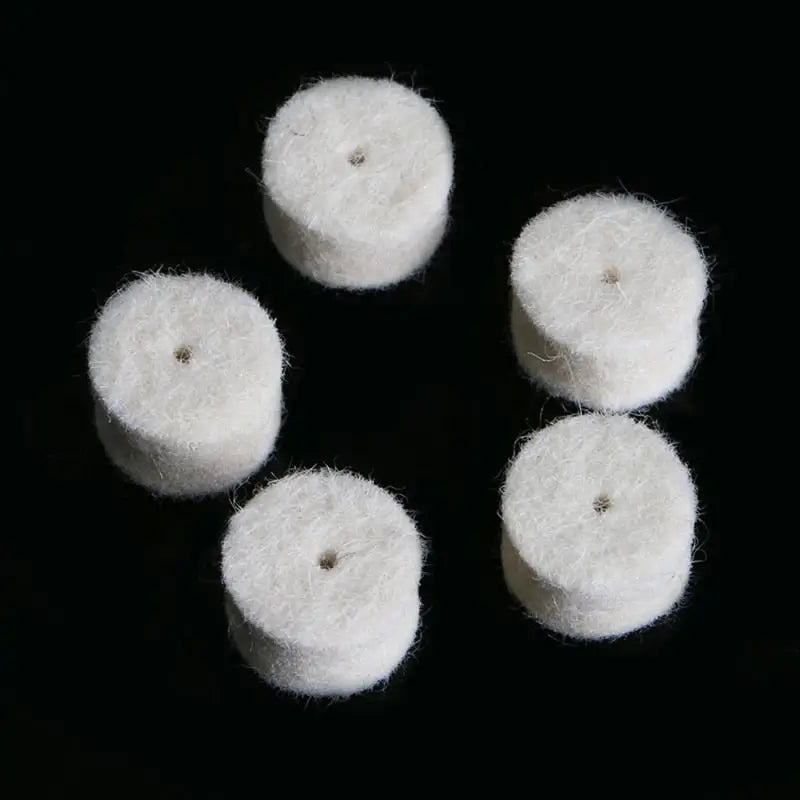 four white wool balls on a black background