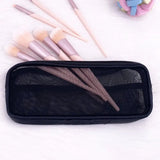 a black bag with a bunch of makeup brushes and a pink and blue brush