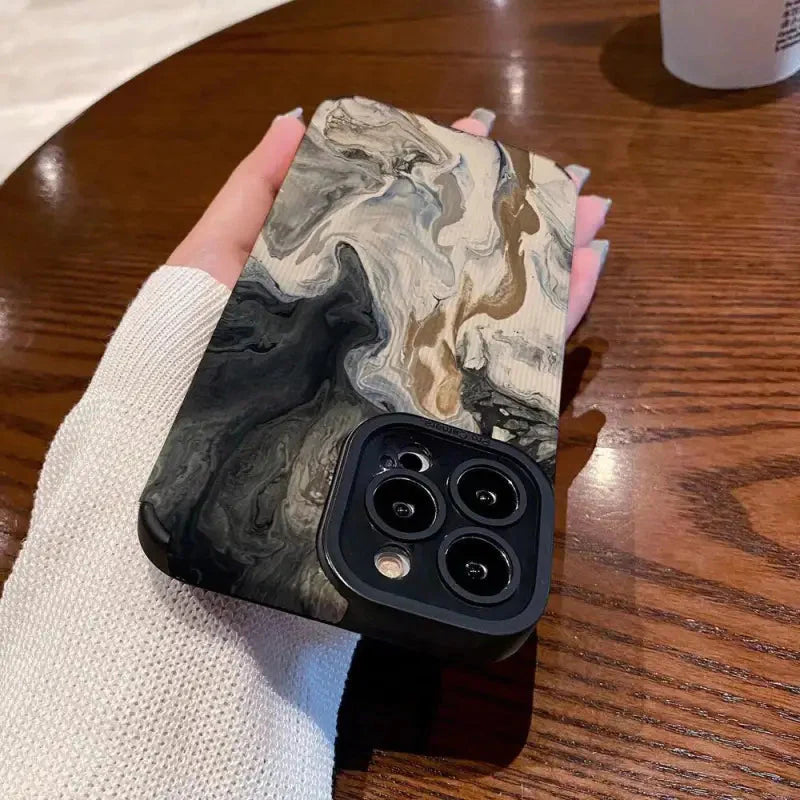 a hand holding a black and white marble phone case