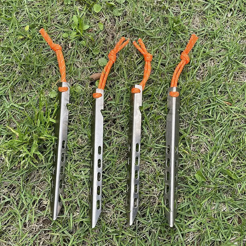 two orange handled knives on grass