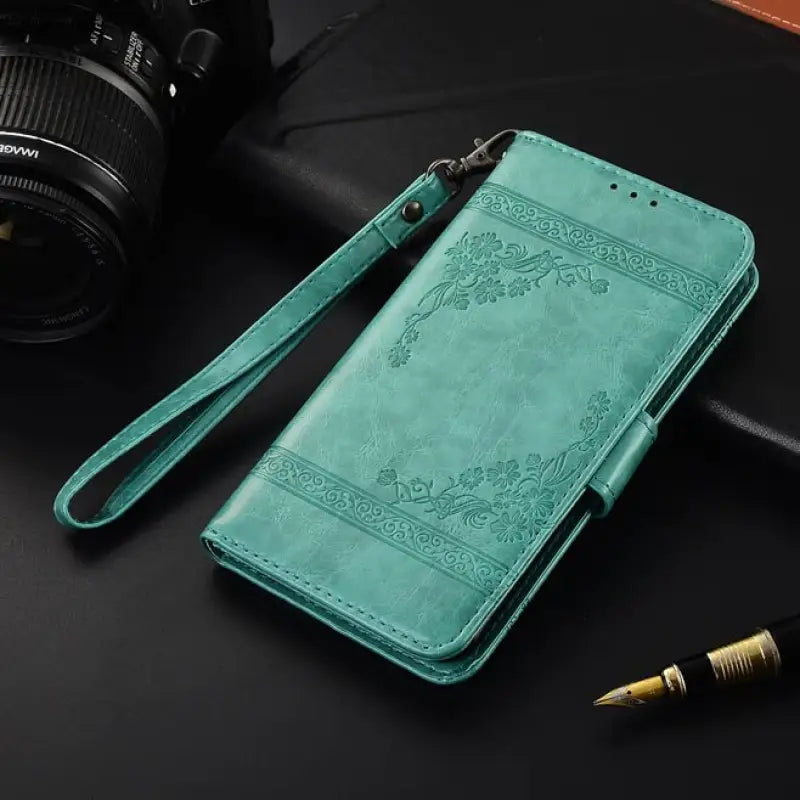 a green leather case with a camera and a pen