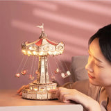 a woman is holding a toy carousel