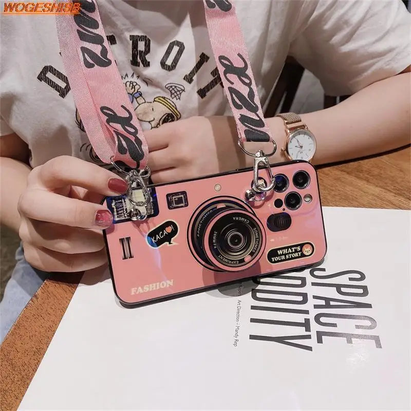 a girl holding a camera with a pink strap