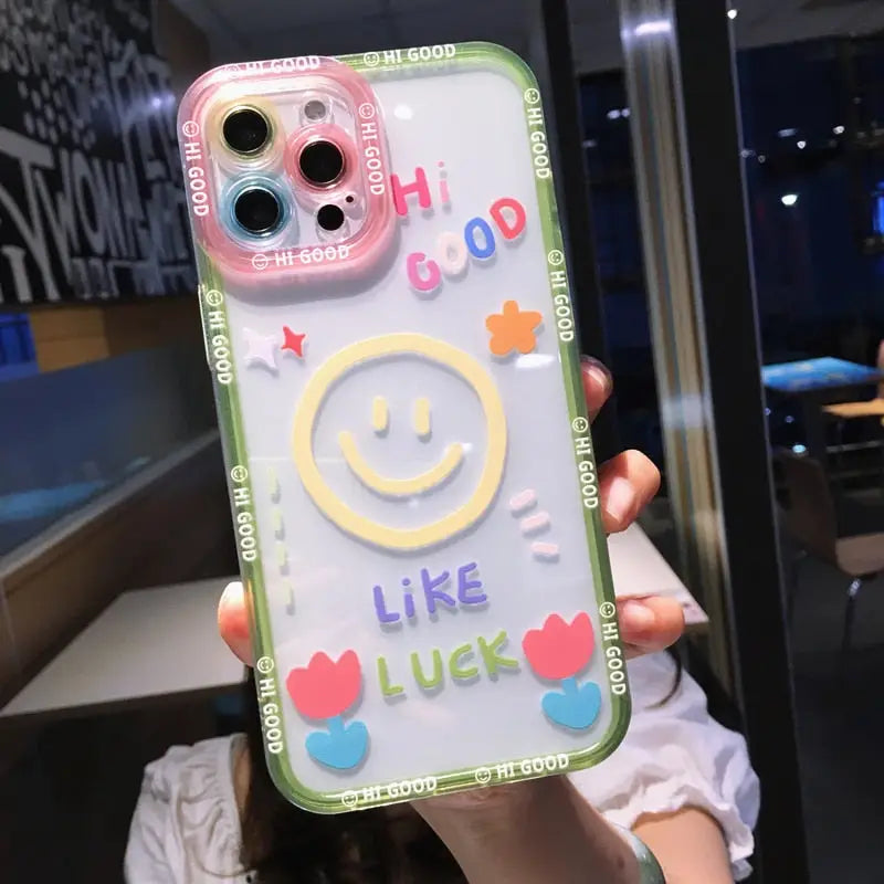 a girl holding up a phone case with a smiley face