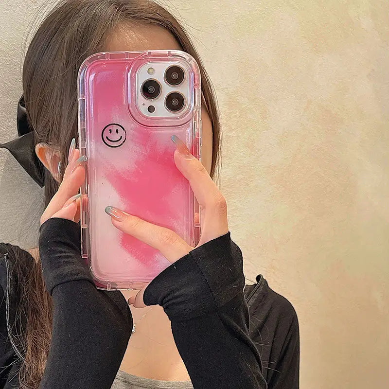 a girl holding up her phone case with a smiley face on it