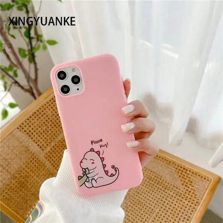 A girl holding a pink phone case with a cartoon cat