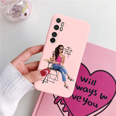 a girl sitting on a chair with a heart phone case