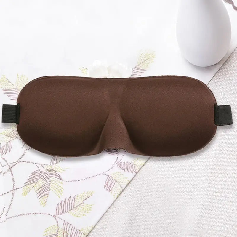 a brown eye mask with a black strap