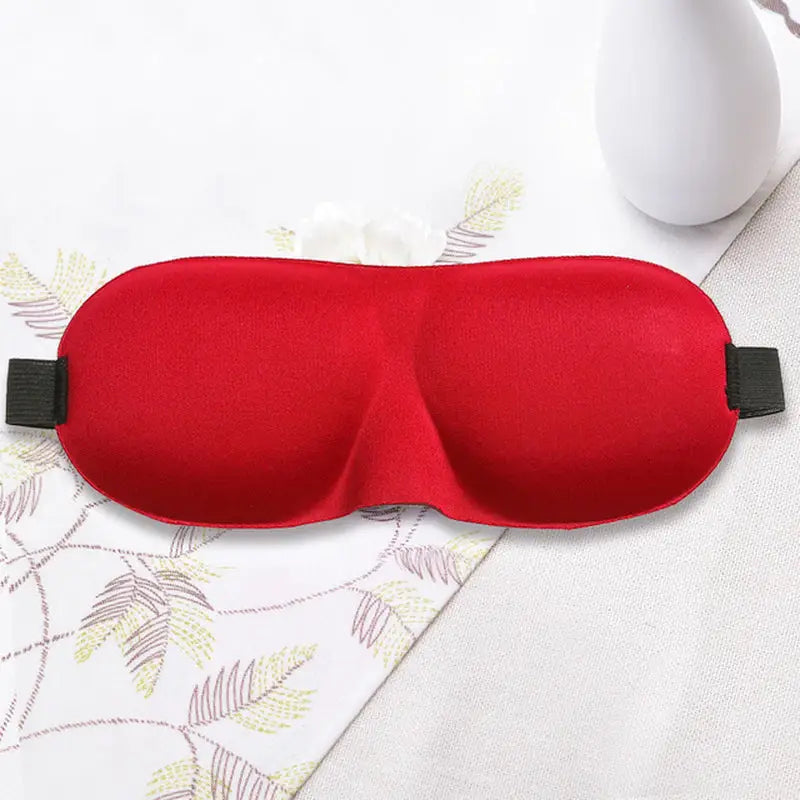 a red eye mask with a black strap