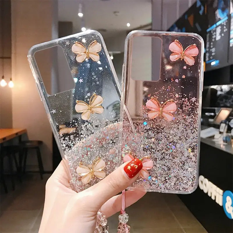 a woman holding a phone case with glitter and butterflies