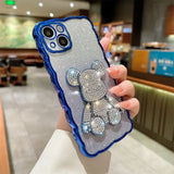 a woman holding a phone case with a blue and silver glitter turtle