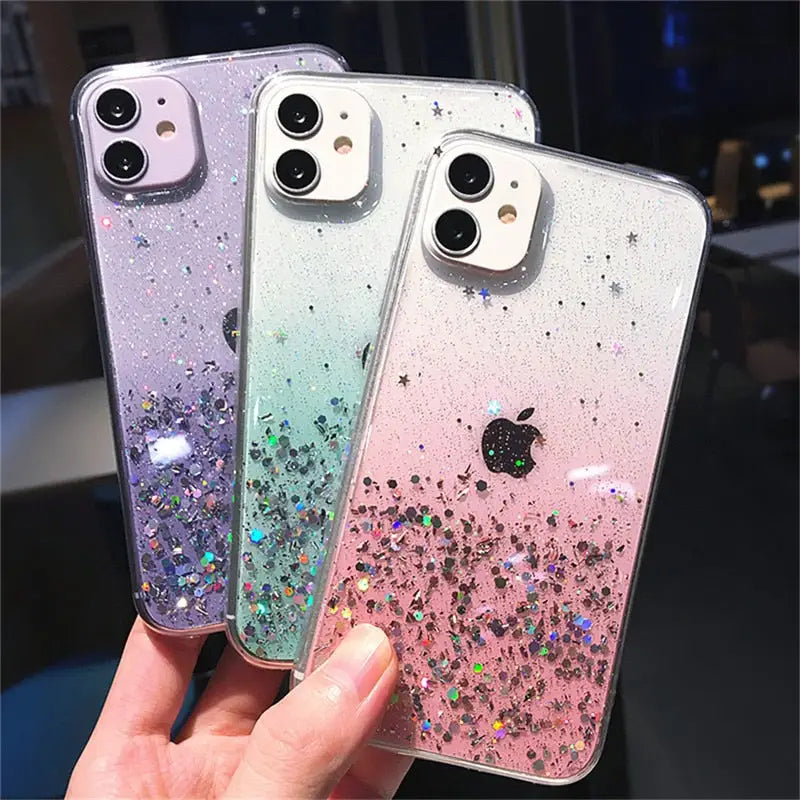 a hand holding two iphone cases with glitter on them