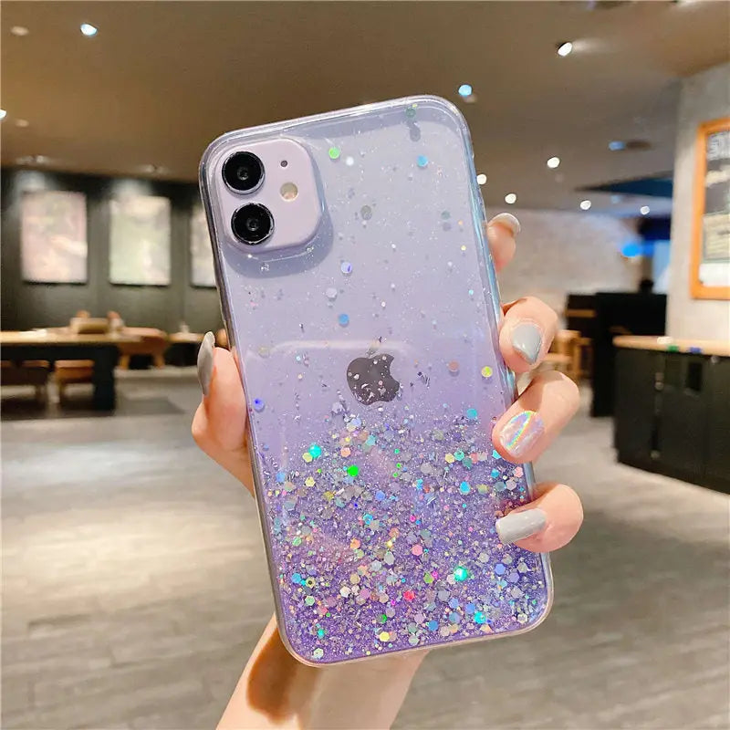 a woman holding up a purple phone case with glitter