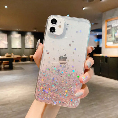 a woman holding up a phone case with glitter