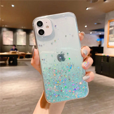 a woman holding a phone case with glitter